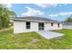 The backyard shows the house, green grass, and a patio area for outdoor enjoyment at 55 Locust Loop Cir, Ocala, FL 34472
