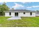 The backyard shows the house, green grass, and a patio area for outdoor enjoyment at 55 Locust Loop Cir, Ocala, FL 34472