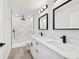 Modern bathroom with double vanity, framed mirrors, and walk-in shower with marble tiling at 55 Locust Loop Cir, Ocala, FL 34472