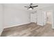 Spacious bedroom with wood-look flooring, ceiling fan, and en suite bathroom at 55 Locust Loop Cir, Ocala, FL 34472