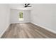 Bright bedroom featuring wood floors, a ceiling fan, and natural light from the window at 55 Locust Loop Cir, Ocala, FL 34472