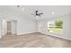 Bright bedroom featuring light wood floors, a ceiling fan, and an ensuite bathroom with modern fixtures at 55 Locust Loop Cir, Ocala, FL 34472