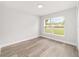 Bedroom features wood-look flooring and a window overlooking the lawn at 55 Locust Loop Cir, Ocala, FL 34472