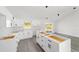 Modern kitchen with white cabinets, gray vinyl flooring and an island at 55 Locust Loop Cir, Ocala, FL 34472