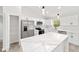 Modern kitchen featuring white cabinets, stainless steel appliances, and a large marble island at 55 Locust Loop Cir, Ocala, FL 34472