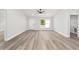 Well-lit living space with light wood floors, a ceiling fan, and convenient access to the laundry area at 55 Locust Loop Cir, Ocala, FL 34472