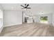 Bright and airy living room with light wood floors, ceiling fan, and an open-concept layout to the kitchen at 55 Locust Loop Cir, Ocala, FL 34472
