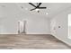 Inviting living area featuring light wood floors, a ceiling fan, and access to the bedroom hallway at 55 Locust Loop Cir, Ocala, FL 34472
