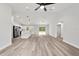 Open-concept living area with light wood flooring, ceiling fan, and seamless transition to the modern kitchen at 55 Locust Loop Cir, Ocala, FL 34472