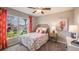 Bedroom with floral bedding, large window, and coral-colored curtains at 7235 Se 113Th Ln, Belleview, FL 34420