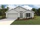 One-story home with gray exterior, two-car garage, and landscaped lawn at 7235 Se 113Th Ln, Belleview, FL 34420