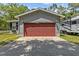 Attached garage with red door and ample space at 7885 Sw 202Nd Ave, Dunnellon, FL 34431