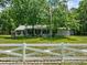 Charming house with a white picket fence and American flag at 7885 Sw 202Nd Ave, Dunnellon, FL 34431