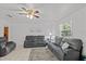 Living room features gray sofas, ceiling fan and large windows at 7885 Sw 202Nd Ave, Dunnellon, FL 34431