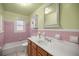 Charming bathroom with pink tile and updated vanity at 820 Ne 42Nd Ter, Ocala, FL 34470