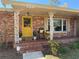 Charming brick home featuring a cozy front porch with decorative columns and a bright yellow front door at 820 Ne 42Nd Ter, Ocala, FL 34470