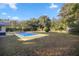 Inviting backyard oasis featuring a refreshing pool, expansive lawn, and mature trees at 820 Ne 42Nd Ter, Ocala, FL 34470