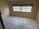 This bedroom features tile flooring and window with blinds at 8973 Sw 101St Ln, Ocala, FL 34481