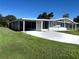 Quaint home featuring covered parking, a screened entry, and lush green lawn at 8973 Sw 101St Ln, Ocala, FL 34481