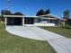 Charming single-story home with carport and screened porch, complemented by lush landscaping at 8973 Sw 101St Ln, Ocala, FL 34481