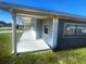 Long covered patio stretches down the side of this single-story home, next to well-kept lawn at 8973 Sw 101St Ln, Ocala, FL 34481