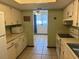 Galley kitchen, painted white, with view to a connecting living room at 8973 Sw 101St Ln, Ocala, FL 34481