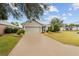 One-story home with a gray garage door and neatly landscaped yard at 9211 Sw 66Th Loop, Ocala, FL 34481