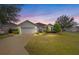 Single-story house with gray siding and a two-car garage, beautifully landscaped at 9211 Sw 66Th Loop, Ocala, FL 34481