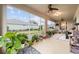 Bright screened porch with ceiling fan and lush potted plants at 9211 Sw 66Th Loop, Ocala, FL 34481