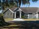 Gray house with stone accents and a three-car garage at 12330 Nw 35Th St, Ocala, FL 34482