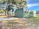 Green metal detached garage with two doors and a white trim at 14320 Se 96Th Ct, Summerfield, FL 34491