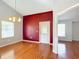 Bright dining room with hardwood floors, red accent wall, and chandelier at 14320 Se 96Th Ct, Summerfield, FL 34491