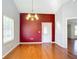 Bright dining room with hardwood floors, red accent wall, and chandelier at 14320 Se 96Th Ct, Summerfield, FL 34491