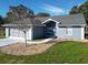 Gray house with a two-car garage and a landscaped yard at 14320 Se 96Th Ct, Summerfield, FL 34491