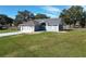 Gray house with a two-car garage and a landscaped yard at 14320 Se 96Th Ct, Summerfield, FL 34491