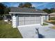 Two car garage with gray doors and white trim at 14320 Se 96Th Ct, Summerfield, FL 34491