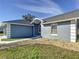 Gray house with a walkway and landscaped yard at 14320 Se 96Th Ct, Summerfield, FL 34491