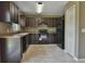 Dark wood cabinets, black appliances, and tile floor at 14448 Sw 75 Cir, Ocala, FL 34473