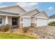 House exterior with two-car garage, stone accents, and landscaping at 17920 Sw 66Th Pl, Dunnellon, FL 34432