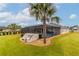 Screened pool and patio area with lush landscaping and palm trees at 17920 Sw 66Th Pl, Dunnellon, FL 34432