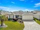 Single-story home with landscaped yard, paver driveway, and two-car garage at 1918 Walden Way, The Villages, FL 32162