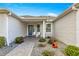 Front porch with blue door and white chairs, surrounded by landscaping at 1918 Walden Way, The Villages, FL 32162