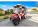 Red and white Club Car golf cart parked on paver driveway at 1918 Walden Way, The Villages, FL 32162