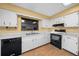 Bright kitchen features white cabinets, black appliances, and wood-look flooring at 1981 Se 54Th Ter, Ocala, FL 34480