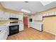 Kitchen with white cabinets, black appliances, and wood-look flooring at 1981 Se 54Th Ter, Ocala, FL 34480