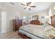 Bedroom with wooden furniture, ceiling fan, and access to bathroom at 2111 Nw 58Th Ct, Ocala, FL 34482