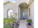 Front entrance with arched entryway, decorative door, and potted plants at 2111 Nw 58Th Ct, Ocala, FL 34482