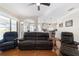 Bright living room featuring hardwood floors and comfortable leather reclining furniture at 2111 Nw 58Th Ct, Ocala, FL 34482