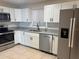 Modern kitchen featuring white cabinets, granite counters, and stainless steel appliances at 2317 Ne 37Th St, Ocala, FL 34479