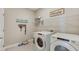 Bright laundry room with washer, dryer, and ample shelving at 3091 Canopy Oak Blvd, Wildwood, FL 34785